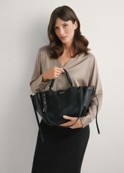 Čierna dámska kabelka cez rameno TOREC-1231-99(W26), pohľad na produkt v rukách modelky. Viditeľná polovica siluety.