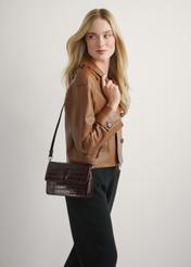 Malá hnedá kabelka z krokodílej kože TORES-1233-1H(W26), pohľad na produkt na ramene modelky. Viditeľná polovičná silueta.