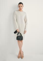 Malá čierna dámska kabelka TOREC-1174-99(W26), pohľad na produkt v ruke modelky. Viditeľné celé telo.