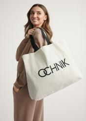 Bavlnená ecru kabelka TOREN-0136-1E(W26) - pohľad spredu na produkt, na modelke, na svetlom pozadí. Viditeľná silueta po pás.