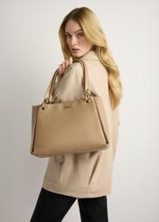 Dámska béžová kabelka z imitácie kože TOREC-0998-1D(W26) - pohľad spredu na produkt, ktorý drží modelka, na svetlom pozadí. Viditeľná silueta po kolená.