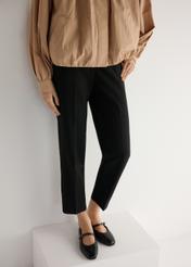 Čierne kožené balerínky s opaskom BUTYD-1145-99(W25), pohľad na produkt spredu na modelke, viditeľná polovica siluety.