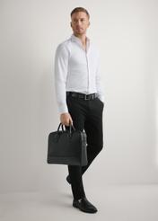 Čierna kožená taška na notebook TORMS-0494-99(W26) - mierne diagonálny pohľad na produkt, držaný v ruke modelky, na svetlom pozadí.