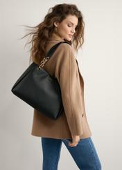 Čierna dámska kabelka z imitácie kože TOREC-0998-99(W25), pohľad spredu na produkt na modelke, viditeľná polovica siluety.