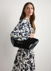 Čierna dámska kabelka cez rameno TOREC-1237-99(W26) - pohľad spredu na produkt, na modelke, na svetlom pozadí. Viditeľná polovica siluety.