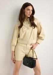 Dámska kabelka z čiernej lakovanej kože TORES-1297-99(W26), pohľad na produkt v ruke modelky. Viditeľná polovica siluety.