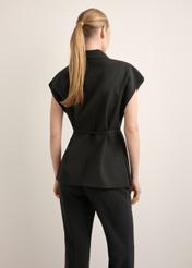 Dámska čierna oversize vesta KAMDT-0039-99(Z26), pohľad zozadu na produkt na modelke. Viditeľná polovica siluety.