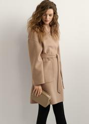 Béžová malá dámska kabelka TOREC-1126-1D(W26), pohľad na produkt v ruke modelky. Viditeľná polovica siluety.