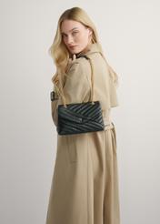 Dámska čierna kožená kabelka TORES-1285-99(W26) - pohľad na produkt na modelke, na svetlom pozadí. Viditeľná polovica siluety.