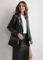 Čierna malá dámska kabelka TOREC-1126-99(W26), pohľad spredu na produkt na modelke, viditeľná polovica siluety.