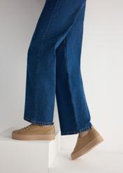 Béžové dámske kožené tenisky BUTYD-1062-1B(W26), bočný pohľad na produkt na modelke, viditeľná polovica siluety.