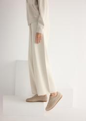 Dámske semišové béžové topánky BUTYD-1261-1A(W26), bočný pohľad na produkt na nohách modelky, na svetlom pozadí.