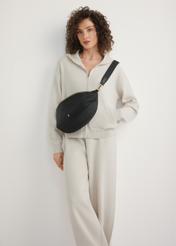 Veľká čierna dámska ľadvinka TOREN-0345-99(W26) - pohľad spredu na produkt, na modelke, na svetlom pozadí. Viditeľná je celá silueta.