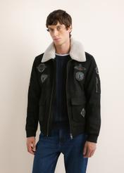 Čierna kožená bomber bunda KURMS-0423-99(Z26), pohľad spredu na produkt na modelke. Viditeľná polovica siluety.