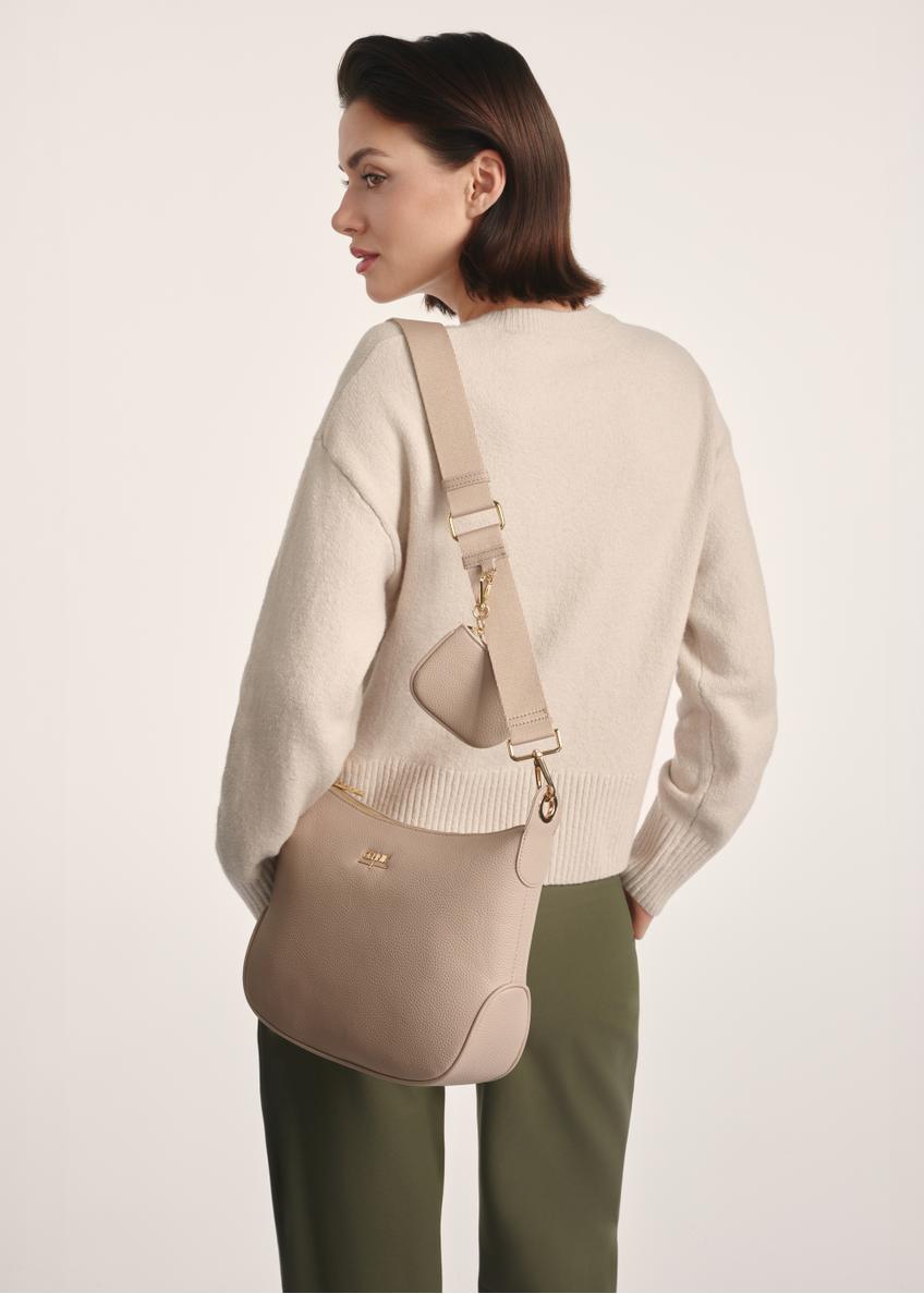 Béžová dámska kabelka v štýle hobo TOREC-0829 A-80(Z 25), pohľad na produkt na ramene modelky. Viditeľná polovica siluety.