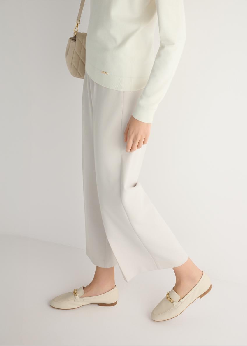 Dámske krémové kožené mokasíny s retiazkou BUTYD-0914A-0B(W26), bočný pohľad na produkt na modelke, viditeľná polovica siluety.