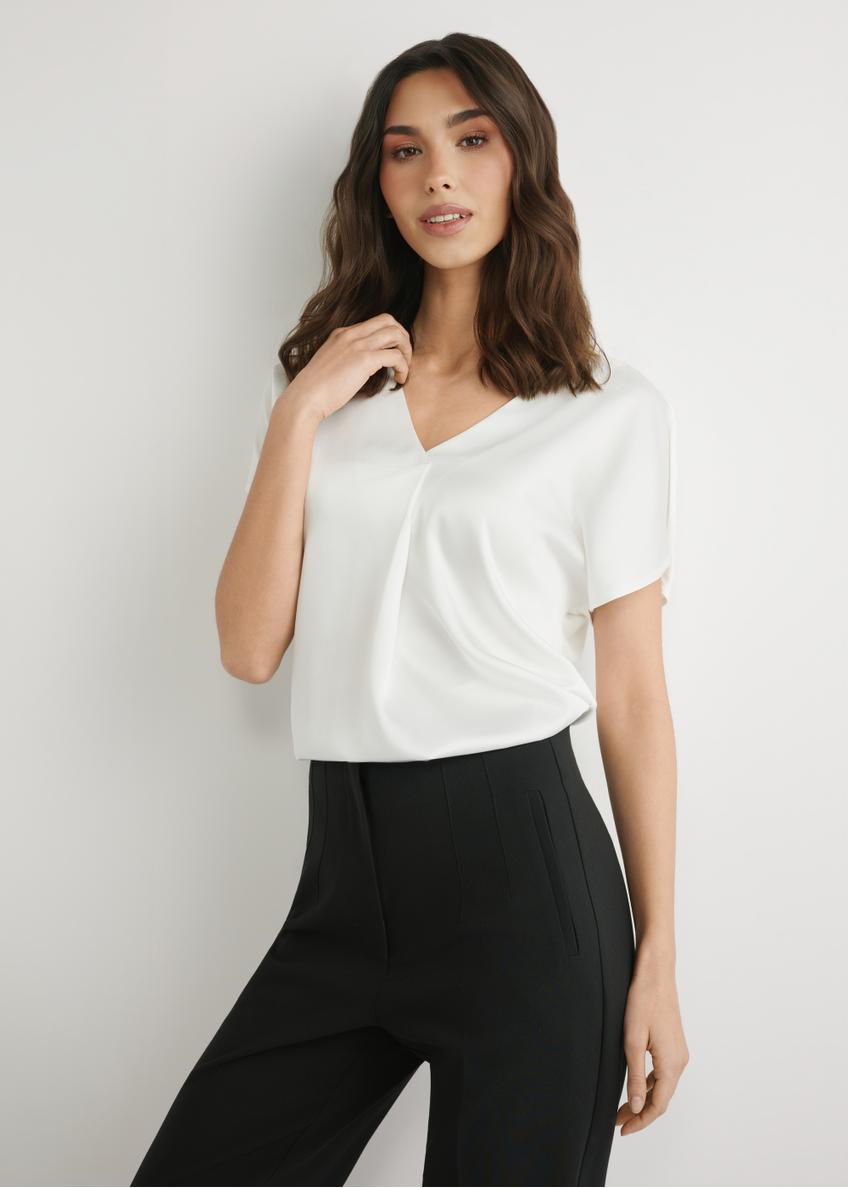 Dámska blúzka krémovej farby BLUDT-0206-0B(W26), pohľad spredu na produkt na modelke. Viditeľná polovica siluety.