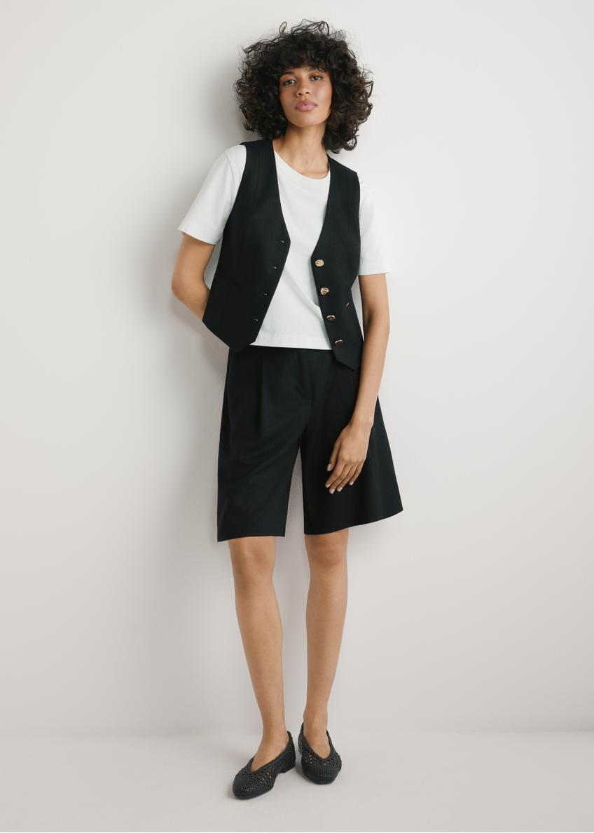 Dámske elegantné čierne šortky SZODT-0017-99(W26), pohľad spredu na produkt na modelke. Viditeľné celé telo.