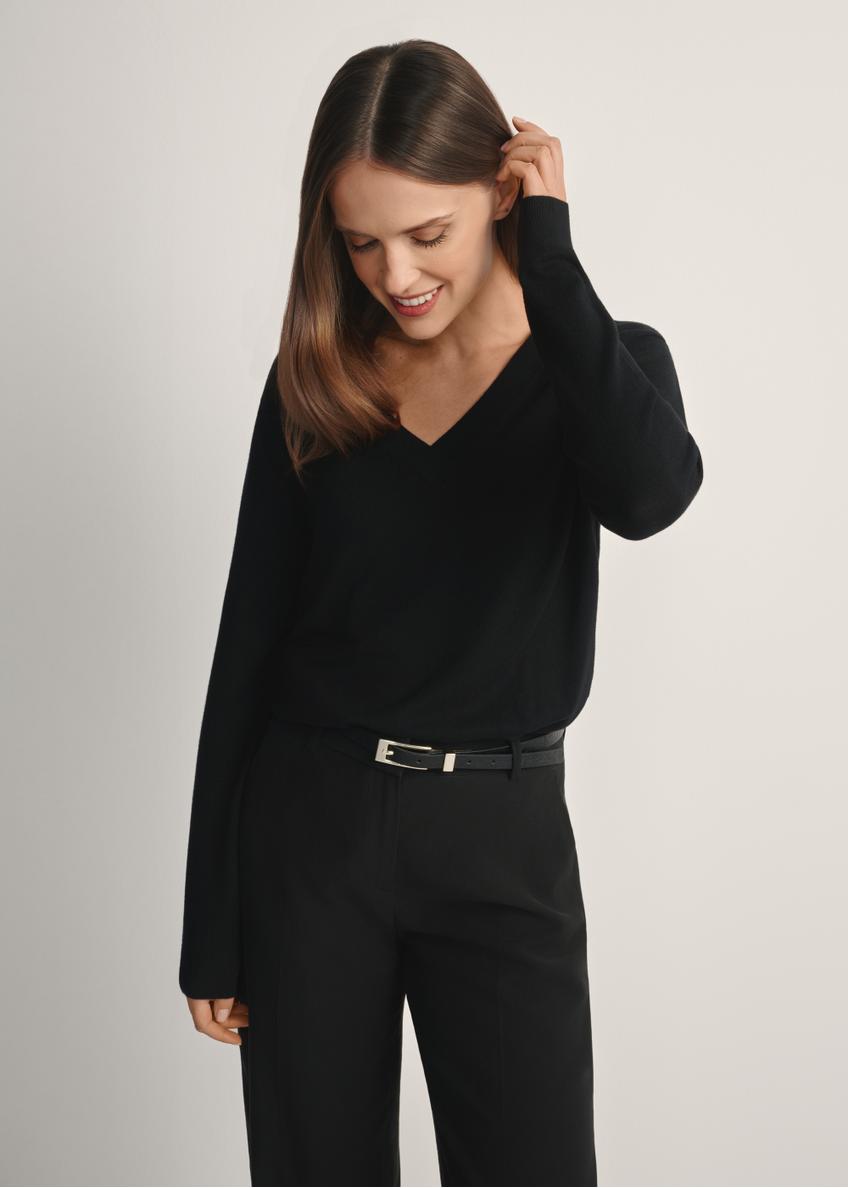Čierny sveter s výstrihom do V SWEDT-0201-99(W24), pohľad na produkt spredu na modelke, viditeľná polovica siluety.