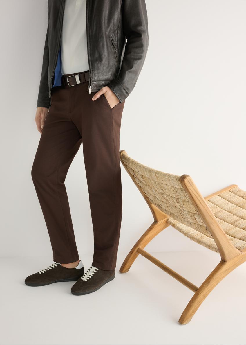 Tmavohnedá kožená športová obuv BUTYM-0534-1I(W26), bočný pohľad na produkt na nohách modelky, na svetlom pozadí.