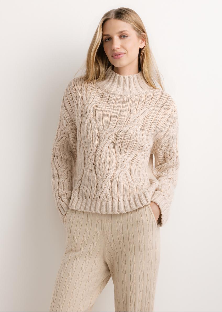 Dámsky oversized sveter vo svetlobéžovej farbe SWEDT-0278-1A(Z26), pohľad na produkt spredu na modelke. Viditeľná polovica siluety.