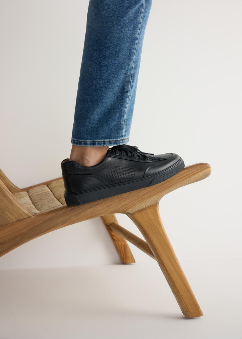 Pánske kožené tenisky v tmavomodrej farbe BUTYM-0484-7E(W26), bočný pohľad na produkt na modeli, viditeľná polovica siluety.
