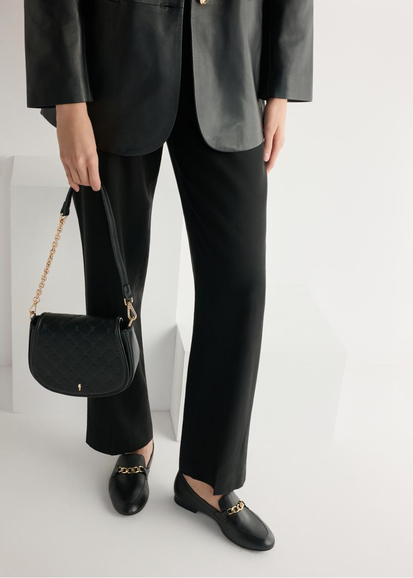 Dámske čierne kožené mokasíny s retiazkou BUTYD-0914A-99(W26), bočný pohľad na produkt na modelke, viditeľná polovica siluety.