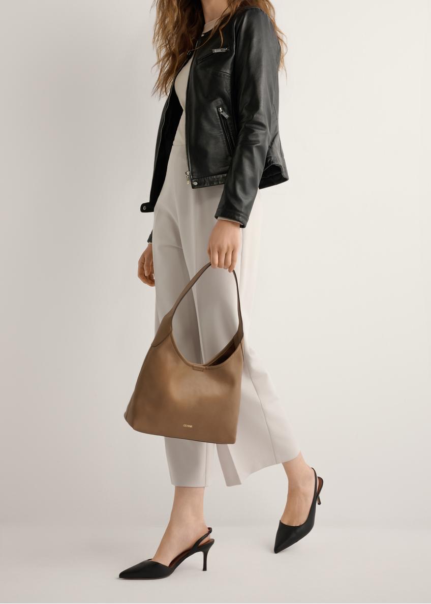 Čierne kožené lodičky s vykrojeným podpätkom BUTYD-1078A-99(W26), bočný pohľad na produkt na nohách modelky, na svetlom pozadí.