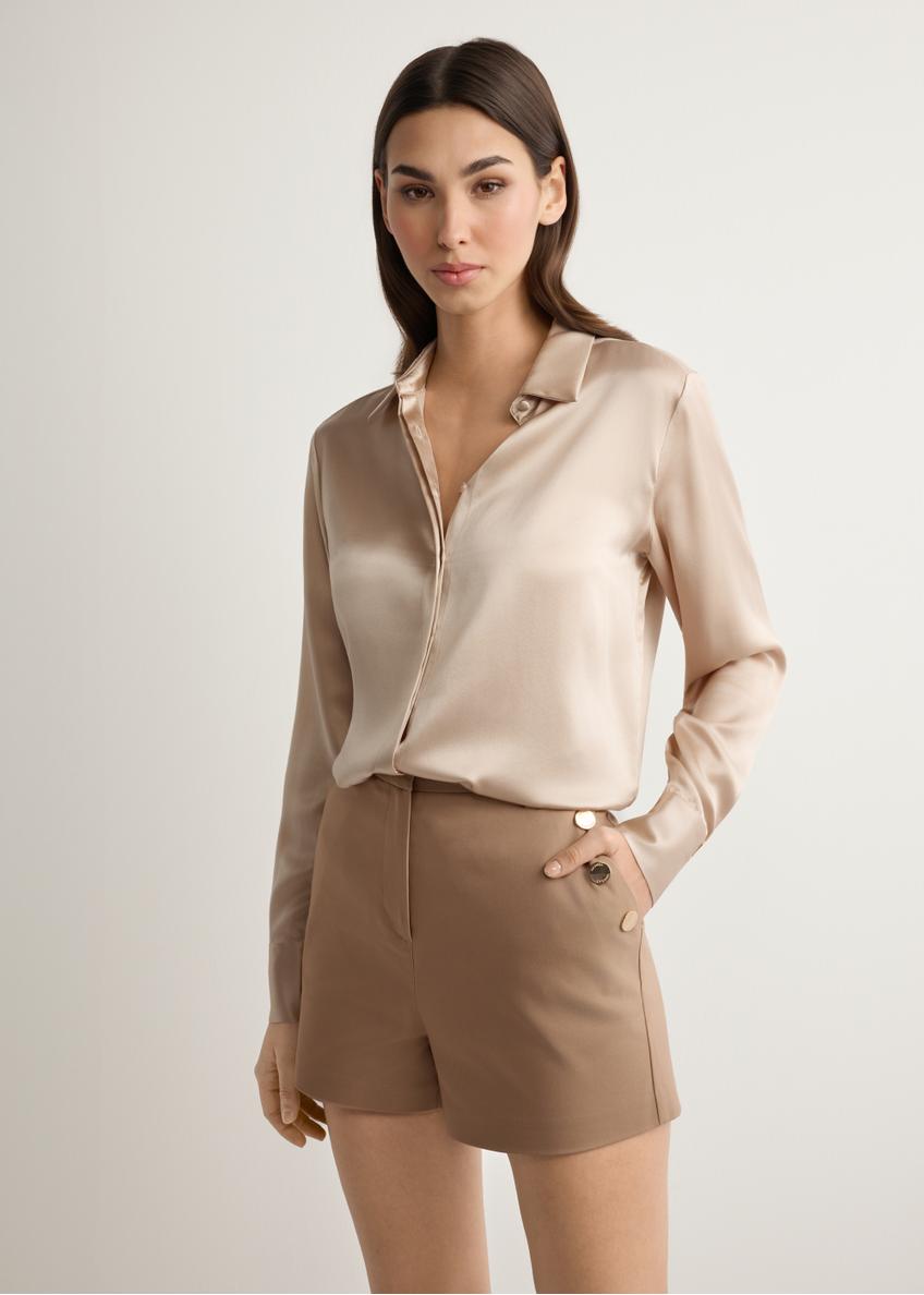 Dámske elegantné šortky v ťavej farbe SZODT-0018-1D(W26), pohľad spredu na produkt na modelke. Viditeľná polovica siluety.