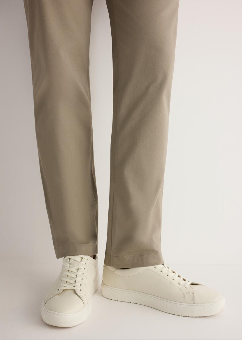 Biele kožené športové topánky BUTYM-0503A-0B(W26), bočný pohľad na produkt na modeli, viditeľná polovica siluety.