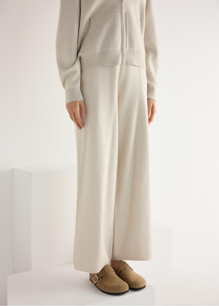 Dámske semišové žabky v chladnej béžovej farbe BUTYD-1267-1K(W26), diagonálny pohľad na produkt na nohách modelky.