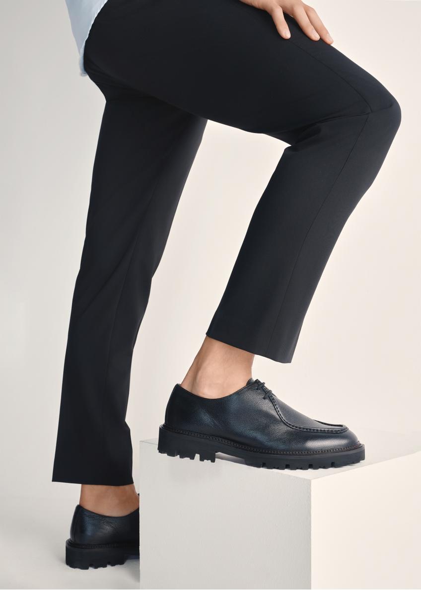 Čierne pánske kožené topánky BUTYM-0524-99(Z25), pohľad na produkt na nohách modelu na svetlom pozadí.