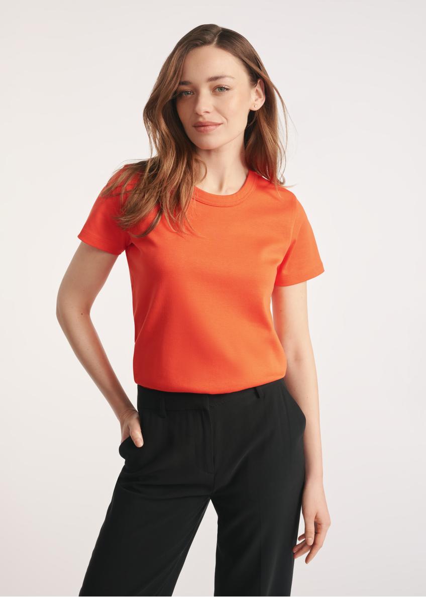 Oranžové bavlnené dámske tričko TSHDT-0144-30(Z25) - pohľad spredu na produkt na modelke na bielom pozadí. Viditeľná je polovica siluety.