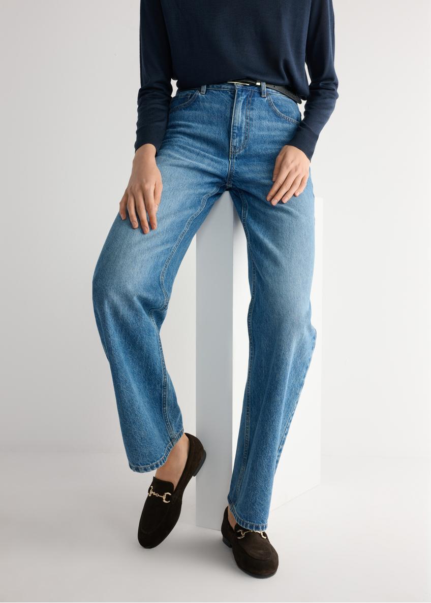 Dámske hnedé semišové mokasíny BUTYD-1257-1I(W26), pohľad na produkt na nohách modelky na svetlom pozadí.