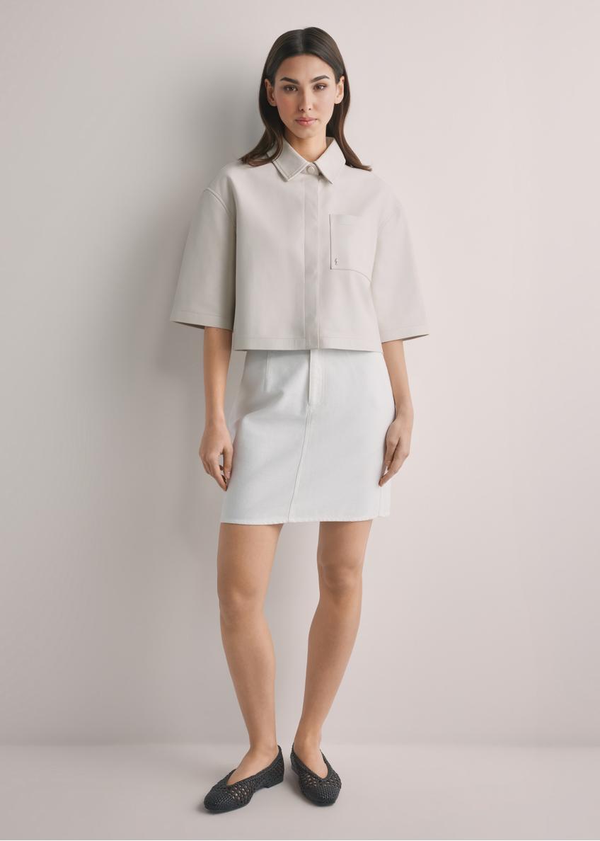 Krémová džínsová minisukňa SPCDT-0126-0B(W26), pohľad spredu na produkt na modelke. Viditeľné celé telo.