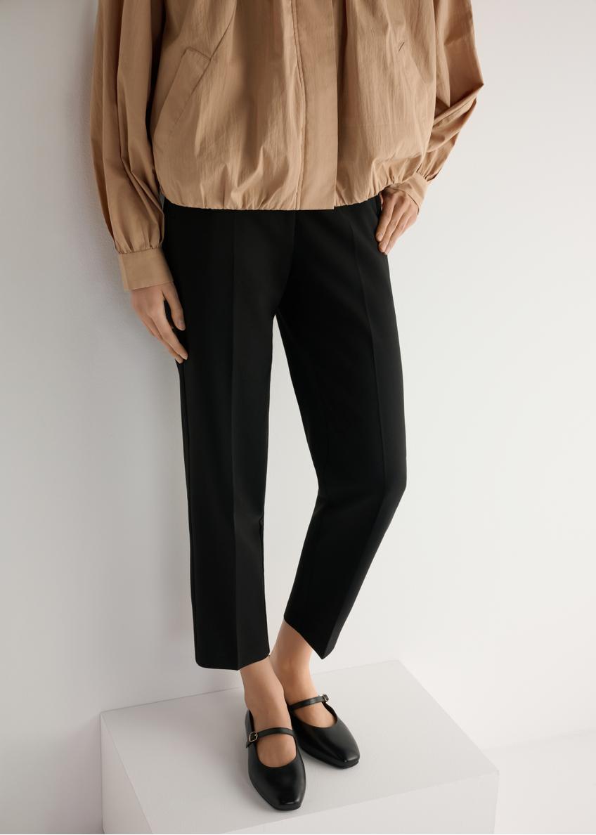 Čierne kožené balerínky s opaskom BUTYD-1145-99(W25), pohľad na produkt spredu na modelke, viditeľná polovica siluety.