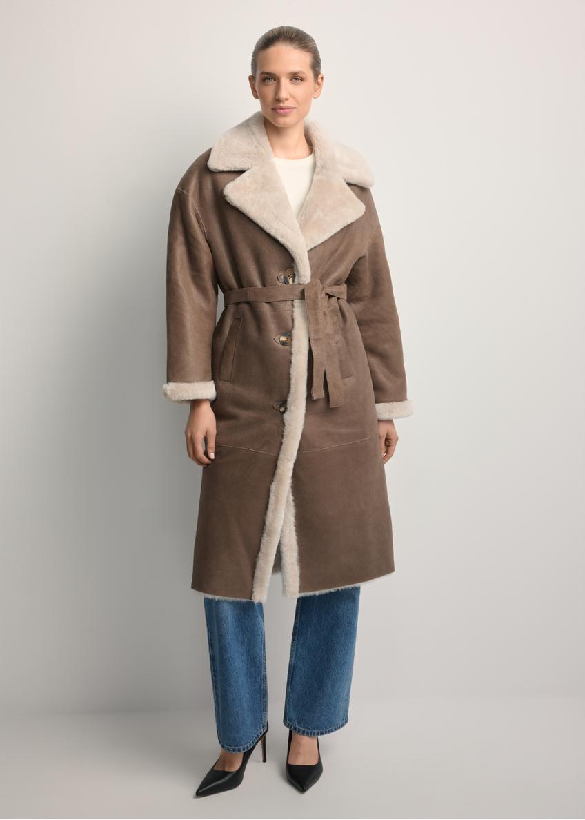 Dlhý klasický hnedý dámsky kabát z ovčej kože KOZDS-0071-3091(Z25), pohľad spredu na modelku. Viditeľné celé telo.