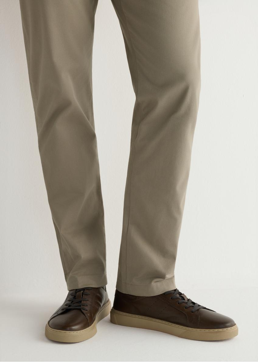 Pánske tmavohnedé kožené tenisky BUTYM-0486-1I(W26), pohľad na produkt na nohách modelky.