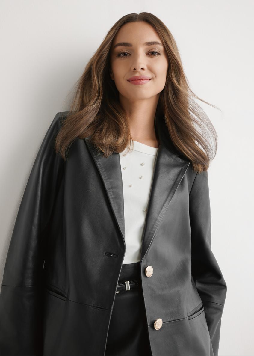 Dámska čierna kožená bunda KURDS-0606-99(W26) - pohľad spredu na výrobok, na modelke, na svetlom pozadí. Viditeľná polovica siluety.